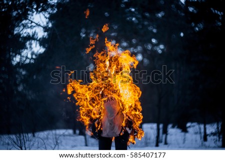 Burning clothing per person. A burning silhouette of a man. Image of a man on fire. Man on Fire. stuntman working on the fire. Day of Fire Performance of movement. Close-up portrait of a burning man.