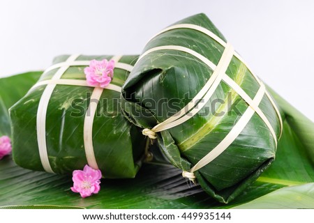 Uncooked Vietnamese Chung Cake isolated on white. It's a square glutinous sticky rice cake, stuffed with pork meat, green beans and wrapped in bamboo leaf. Traditional Vietnamese New Year (Tet) food.