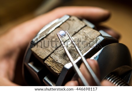 Craft jewelery making with professional tools. Ring repairing. Putting the diamond on the ring. Macro shot. A handmade jeweler process, manufacture of jewelery.