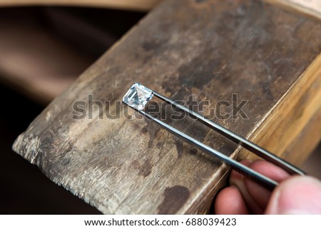 Craft jewelery making with professional tools. Ring repairing. Putting square diamond on the ring. Macro shot. A handmade jeweler process, manufacture of jewellery.
