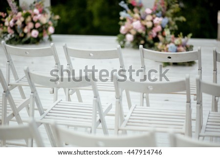 White Garden Chairs Stand In A Ray Waiting For The Wedding Ceremony White Garden Chairs Stand In A Ray Waiting For The Wedding Ceremony