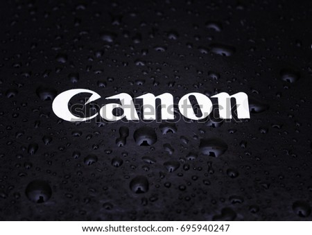 Water drops close-up on a photographic equipment logo CANON