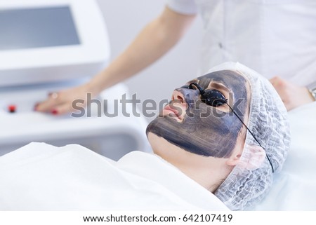 Carbon face peeling procedure. Laser pulses clean skin of the face. Hardware cosmetology treatment. Process of photothermolysis, warming the skin, laser carbon peeling. Facial skin rejuvenation.