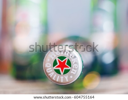 DORKOVO, BULGARIA - MARCH 13, 2017: Macro shot of Heineken bouttle over bar table, colorful club lights .Heineken Lager Beer is the flagship product of Heineken International