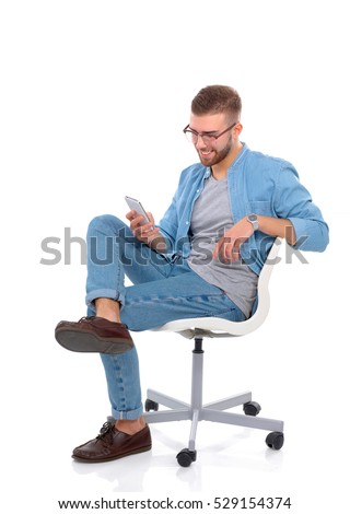 Young man sitting on chair and using mobile phone