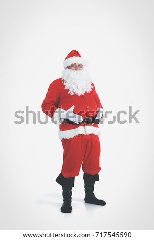 Real Santa Claus carrying big bag full of gifts, isolated on white background.