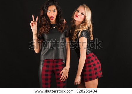 stock-photo-blonde-and-brunette-women-portrait-against-dark-background-with-victory-sign-328251404.jpg