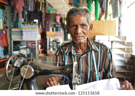 BERUWALA, SRI LANKA - NOVEMBER 13: man sewing in a small tailor shop, industrial sewing machine on November 13, 2012 in Beruwala, Sri Lanka. Sri Lankan private sewing industry.