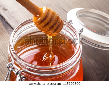 Honey drip in jar on the table