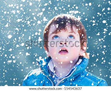 Child looking snow falling with his mouth open