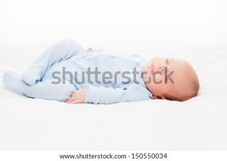 Little cute smiling newborn baby child sleeping bed white isolated