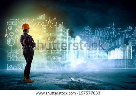 Back view of woman engineer looking at project sketch