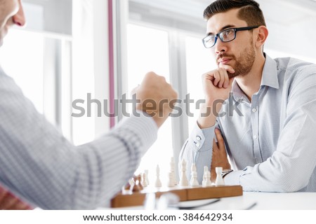 Portrait of two young man playing chess