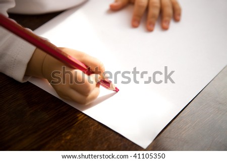 The small child writes the letter to Santa