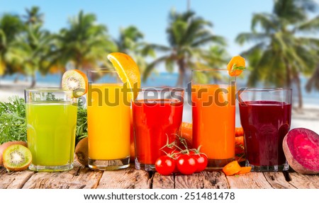 Fresh fruits juices on wood plant with tropical beach