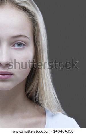 Closeup portrait of a cropped teenage girl against gray background