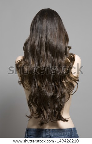 stock photo rear view of a topless woman with long brown wavy hair against gray background 149426210