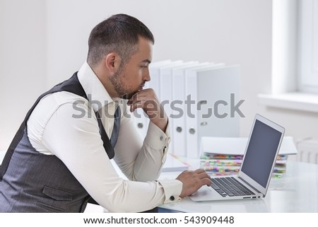 Young businessman using at laptop at desk