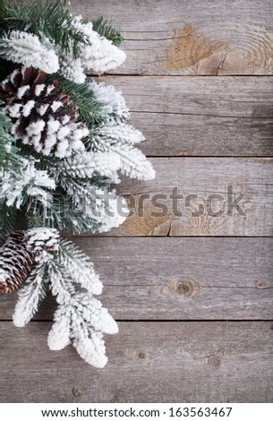 Fir tree covered with snow on wooden board