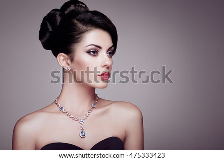 Fashion portrait of young beautiful woman with jewelry and elegant hairstyle. Brunette girl. Perfect make-up. Beauty style woman with diamond accessories