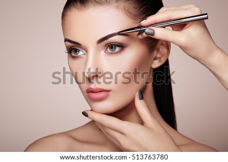 Đẹp người phụ nữ tóc nâu vẽ lông mày. người phụ nữ khuôn mặt xinh đẹp. chi tiết trang điểm. Vẻ đẹp cô gái với làn da hoàn hảo