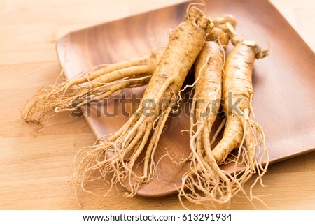 Fresh ginseng root over wooden background