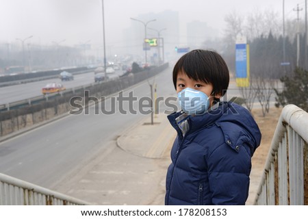 Asian boy wearing mouth mask against air pollution (Beijing)