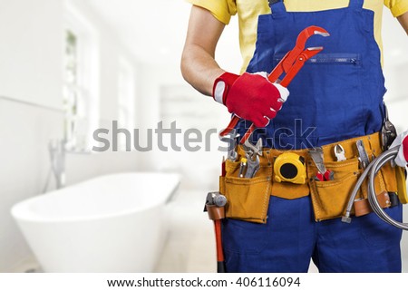 plumber with tool belt standing in bathroom