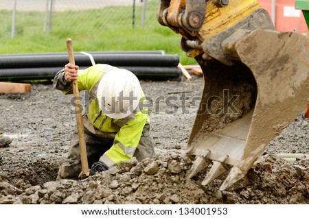 stock-photo-worker-using-a-small-tracked-excavator-to-dig-a-hole-to-fix-a-water-leak-at-a-large-commercial-134001953.jpg