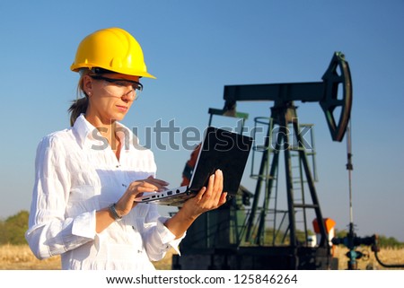 Female engineer in an oilfield working with notebook