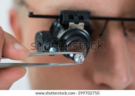 Close-up Of Person Looking At Diamond With Magnifying Loupe