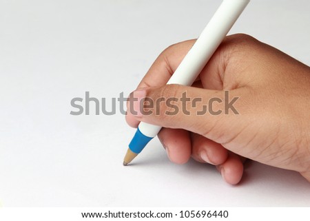 Kid's hand holding a pen against a white paper background