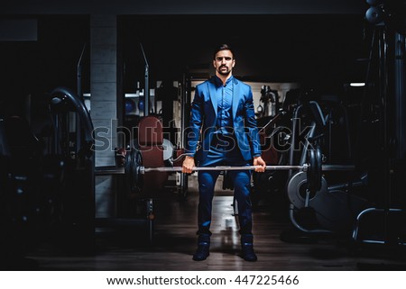 stock-photo-man-in-suit-lifting-heavy-weight-in-the-gym-447225466.jpg