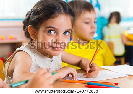Group of cute little preschol kids drawing with colorful pencils