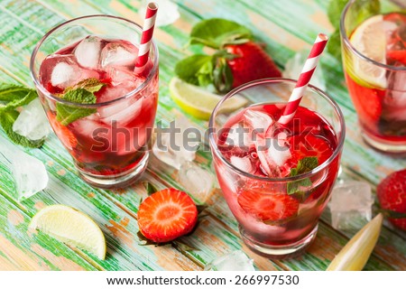 Refreshing summer drink with Strawberry in jug and glasses on the vintage wooden table - stock photo