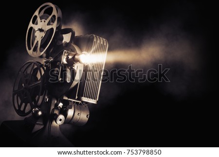 Movie projector on a dark background with light beam / high contrast image