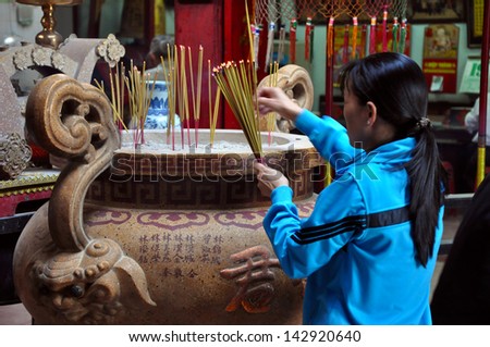 CAN THO - FEB 17: Unidentified believers offering food and incense sticks for the Gods in the Vietnamese Ong Buddhist temple. On February 17, 2013, in Can Tho, Mekong Delta, Vietnam