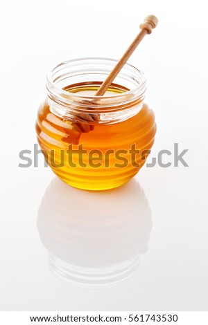 jar of honey with honeycomb on white