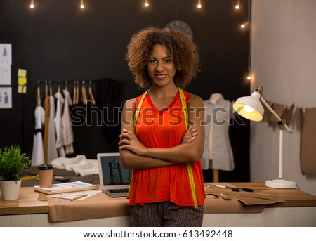 Portrait of a young fashion designer working on her atelier