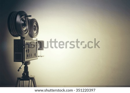 Old style movie camera with white wall, vintage photo effect