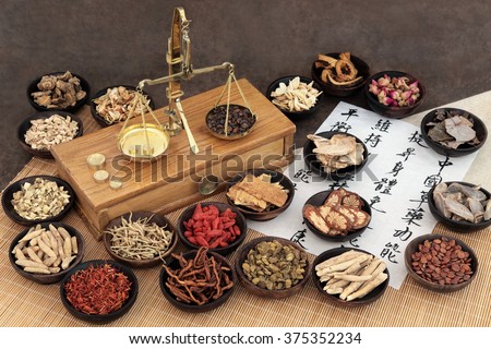 Chinese medicine ingredients with scales and calligraphy. Translation reads as chinese herbal medicine as increasing the bodys ability to maintain body and spirit health and balance energy.