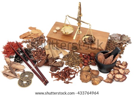 Chinese herbal medicine with traditional herb ingredients and old brass scales over white background.
