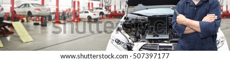 Hands of car mechanic with wrench in garage.