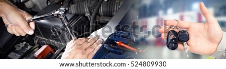 Hands of car mechanic with wrench in garage.