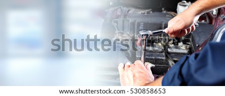 Hands of car mechanic in auto repair service.