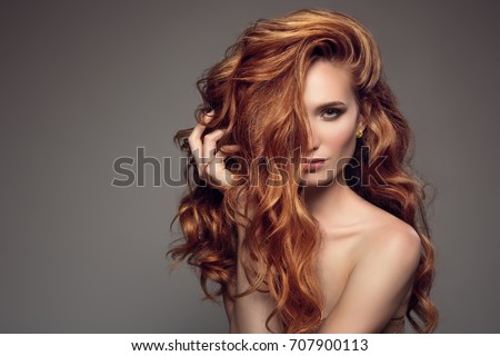 Portrait of woman with long curly beautiful ginger hair.
