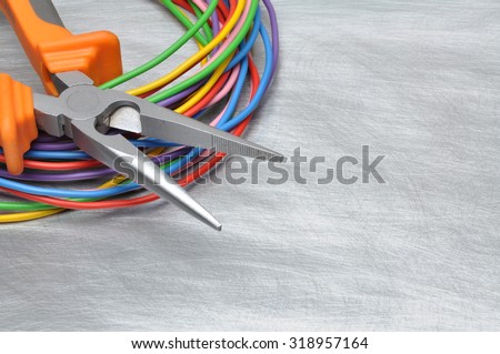 Tools for electrician and cables on grey metal surface
