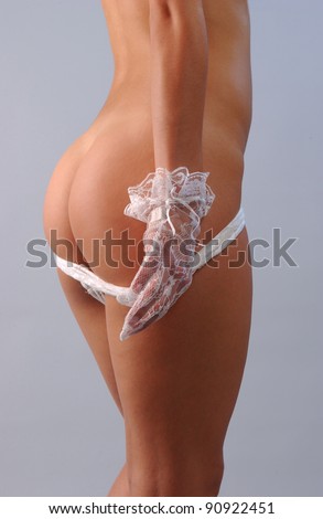 perfect body of elegant young lady in white sexy lingerie and gloves on isolated grey background.