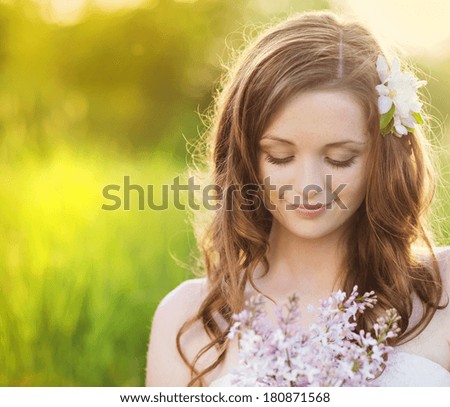 stock photo beautiful woman with flowers in spring sunshine girl is holding a lillac on the green meadow 180871568