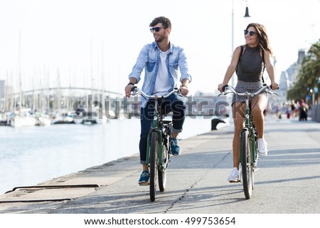 Portrait of happy young couple cycling in the city.